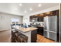 Modern kitchen with stainless steel appliances, central island and wooden stools at 2404 Horse Shoe Cir, Fort Lupton, CO 80621