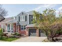 Charming two-story home featuring a manicured lawn, brick accents, and an attached two-car garage at 674 Huntington Dr, Highlands Ranch, CO 80126