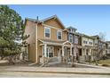 Street view of a tan two-story townhome with a welcoming front porch and manicured landscaping at 15612 E 96Th Way # 29A, Commerce City, CO 80022