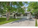 A charming two-story home with a lush green lawn and mature trees at 3545 Moorhead Ave, Boulder, CO 80305