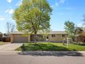 Charming single-story home featuring a well-maintained lawn, large shade tree and an attached two-car garage at 4779 S Owens Way, Littleton, CO 80127