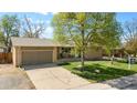 Charming single-story home featuring a well-maintained lawn, large shade tree and an attached two-car garage at 4779 S Owens Way, Littleton, CO 80127