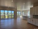 Open floor plan with wood floors, abundant natural light, and seamless integration between living, dining, and kitchen areas at 16655 W 93Rd Pl, Arvada, CO 80007