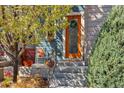 Charming front porch with orange door, wreath, sitting area, and blue siding at 1857 W 67Th Pl, Denver, CO 80221