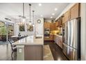 Modern kitchen with stainless steel appliances, a breakfast bar, and stylish pendant lighting at 1857 W 67Th Pl, Denver, CO 80221