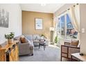 Bright living room with large window, cozy seating, and stylish decor at 1857 W 67Th Pl, Denver, CO 80221