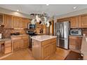 Well-equipped kitchen with stainless steel appliances, island, and beautiful countertops and a pot rack above at 481 Sunrise Dr, Golden, CO 80401