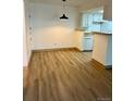 A dining room featuring hardwood floor with a hanging light in front of the kitchen at 4400 S Quebec St # 102R, Denver, CO 80237