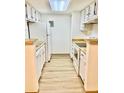 Functional galley kitchen with white cabinetry and appliances at 4400 S Quebec St # 102R, Denver, CO 80237