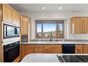 Well-equipped kitchen features granite countertops, wooden cabinets, modern appliances, and a beautiful mountain view at 29011 Upper Moss Rock Rd, Golden, CO 80401