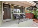Inviting front porch with seating area, wrought iron railing, and classic door with address visible at 4520 S Delaware St, Englewood, CO 80110
