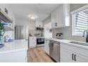 Bright kitchen with white cabinets, stainless steel appliances, and updated fixtures at 4520 S Delaware St, Englewood, CO 80110
