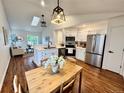 An inviting kitchen with stainless steel appliances, white cabinets, and a dining area bathed in natural light at 4036 S Himalaya Cir, Aurora, CO 80013