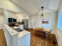 Bright kitchen featuring stainless steel appliances, white cabinets, and an adjacent dining area at 4036 S Himalaya Cir, Aurora, CO 80013