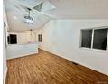 Open-concept living space features vaulted ceilings, modern lighting, and beautiful wood flooring at 4036 S Himalaya Cir, Aurora, CO 80013