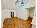 Bright living room featuring wood floors, vaulted ceiling, and a sliding door, creating a modern space at 4036 S Himalaya Cir, Aurora, CO 80013