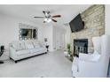 Cozy living room featuring a stone fireplace, modern ceiling fan, and a comfortable seating area at 14242 E Hawaii Cir # C, Aurora, CO 80012
