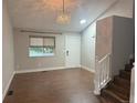 Bright living room with hardwood floors, neutral walls, stairs leading to the second floor, and a large window at 647 Florence Ave, Firestone, CO 80520