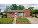 Beautiful brick home with lush green lawn, mature landscaping, and inviting entryway at 920 Emerson Cir, Northglenn, CO 80233