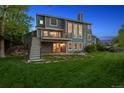 Back exterior showcasing a deck, a covered patio, and a beautifully landscaped backyard at 9728 Ashleigh Ln, Highlands Ranch, CO 80126