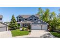 Charming two-story home with a well-manicured lawn, mature trees, and a three-car garage at 9728 Ashleigh Ln, Highlands Ranch, CO 80126