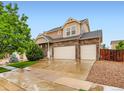 Beautiful two-story home with a three-car garage and stone accents under a clear sky at 10570 Worchester Dr, Commerce City, CO 80022