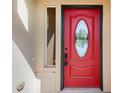 Close-up of a vibrant red front door with decorative glass and black hardware at 7998 Faith Ct, Frederick, CO 80530