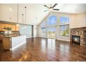 Open-concept living room with hardwood floors, stone fireplace, and abundant natural light at 7998 Faith Ct, Frederick, CO 80530