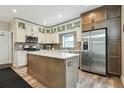Modern kitchen features stainless steel appliances, granite counters, tiled backsplash, and wood-look flooring at 3165 W 63Rd Ave, Denver, CO 80221