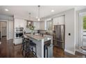 Bright and modern kitchen featuring stainless steel appliances and a central island at 3690 W Byron Pl, Denver, CO 80211