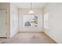 Well-lit dining room with neutral carpet, white walls, and a large window with blinds at 4875 S Balsam Way # 6-102, Littleton, CO 80123
