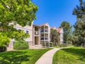 Exterior building view showcasing lush landscaping, a sidewalk, and multiple levels with balconies at 7700 N Depew St # 1518, Arvada, CO 80003