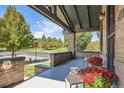 A welcoming covered front porch with brick pillars offering a view of the neighborhood park across the street at 2854 Eliot St, Denver, CO 80211