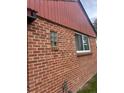 Detailed view of the brick exterior with a small, unique window feature at 2655 Pontiac St, Denver, CO 80207