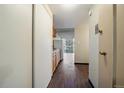 Hallway view of kitchen and living area, featuring hardwood floors and abundant natural light at 4801 E 9Th Ave # 108S, Denver, CO 80220