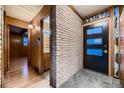 Mid-century modern entry with brick wall and wood floors at 6127 S Westview St, Littleton, CO 80120