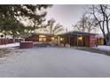 Mid-century modern home with wood siding and snowy front yard at 6127 S Westview St, Littleton, CO 80120