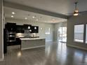 Open-concept kitchen featuring stainless steel appliances, a large island, and modern light fixtures at 10137 Atlanta St, Parker, CO 80134