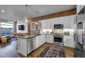 Modern kitchen features stainless steel appliances, brick accent wall, and an island overlooking the living area at 20 N Wilcox St # 218, Castle Rock, CO 80104