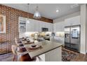 Stylish kitchen with an island including barstool seating, a stainless steel refrigerator, and ample countertop space at 20 N Wilcox St # 218, Castle Rock, CO 80104