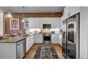 Bright kitchen features stainless steel appliances, white cabinets, and a brick accent wall with modern decor at 20 N Wilcox St # 218, Castle Rock, CO 80104