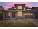 Inviting two-story home with brick and siding, a welcoming front porch, and a two-car garage at 20830 Scenic Park Dr, Parker, CO 80138