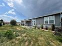 The backyard features a patio area, shrubs, and small trees at 6100 Bluestem # 238, Frederick, CO 80530