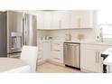 Bright kitchen features white cabinets, stainless appliances, quartz counters, and gold hardware at 3728 W Exposition Ave, Denver, CO 80219