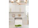 Bright kitchen features white cabinets, stainless appliances, quartz counters, and a stylish gold light fixture at 3728 W Exposition Ave, Denver, CO 80219