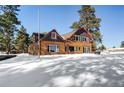 Log home exterior with snowy yard; mountain views in background at 21531 Main Ave, Golden, CO 80401