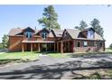 Exterior view of wood sided home with covered porch, manicured lawn and an asphalt driveway at 21531 Main Ave, Golden, CO 80401