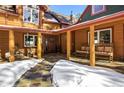 Covered front porch with stone flooring, wooden posts and seating at 21531 Main Ave, Golden, CO 80401