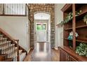 Elegant foyer featuring hardwood floors, a stone archway, and a grand staircase leading to the upper level at 11433 Decatur Ct, Westminster, CO 80234