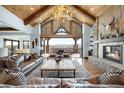 Expansive living room boasts a vaulted ceiling, stone fireplace, and sliding doors to outdoor patio with views at 3148 Keep Dr, Sedalia, CO 80135